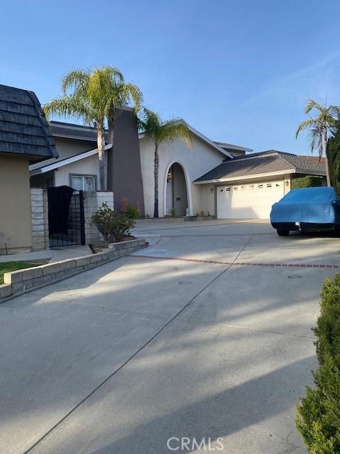 view of front of house featuring driveway, a garage, a gate, and stucco siding