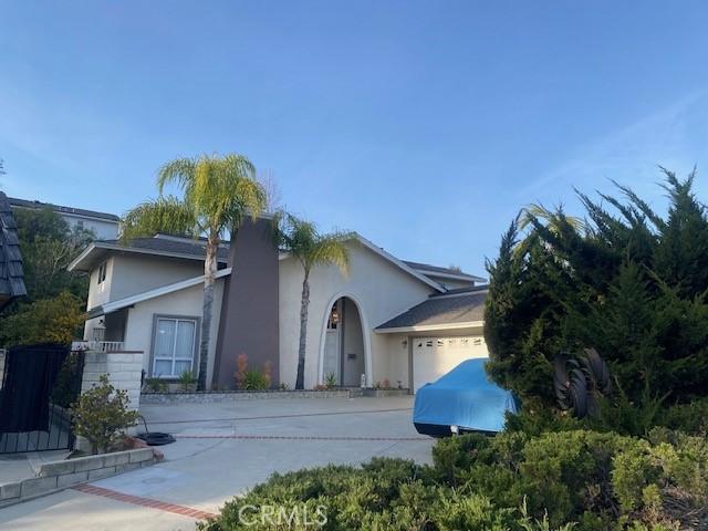 view of side of home featuring a garage, driveway, and stucco siding