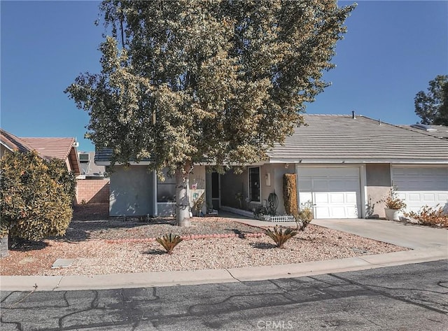 obstructed view of property with a garage, driveway, and stucco siding