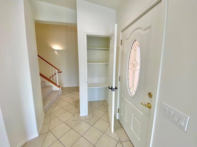 entryway with stairs and light tile patterned flooring