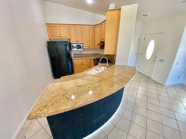 kitchen with light brown cabinetry, light tile patterned floors, black refrigerator with ice dispenser, stainless steel microwave, and a peninsula