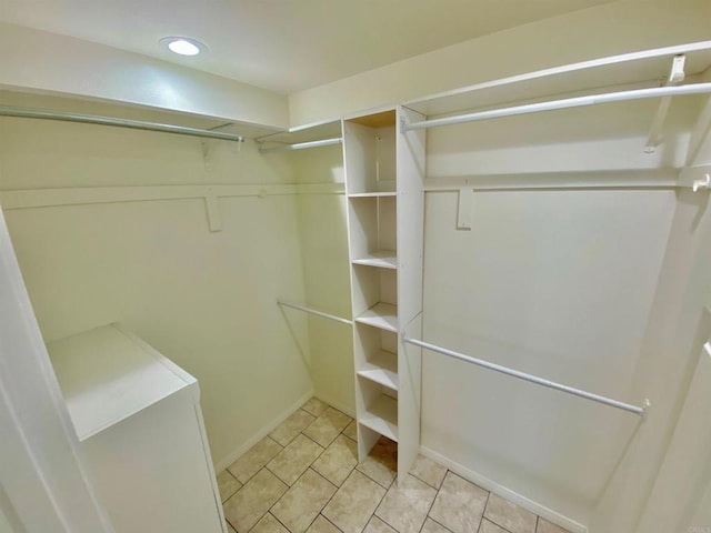 spacious closet with light tile patterned floors