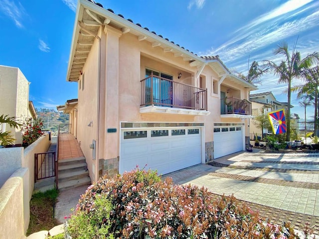 2483 Oxford Ave, Cardiff By The Sea, CA 92007 - view of front of property with stucco siding, an attached garage, driveway, stone siding, and a balcony