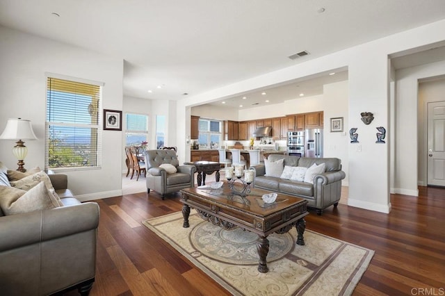 living room with baseboards, visible vents, dark wood-style flooring, and recessed lighting