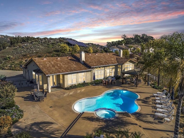 view of pool with a gazebo, a patio, fence, and a pool with connected hot tub