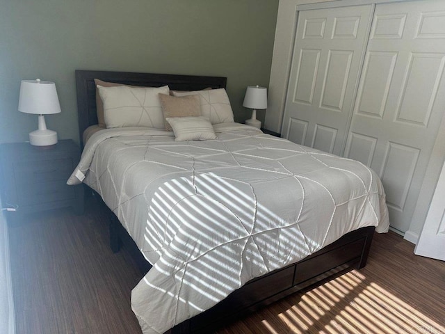 bedroom with dark wood-style floors, baseboards, and a closet