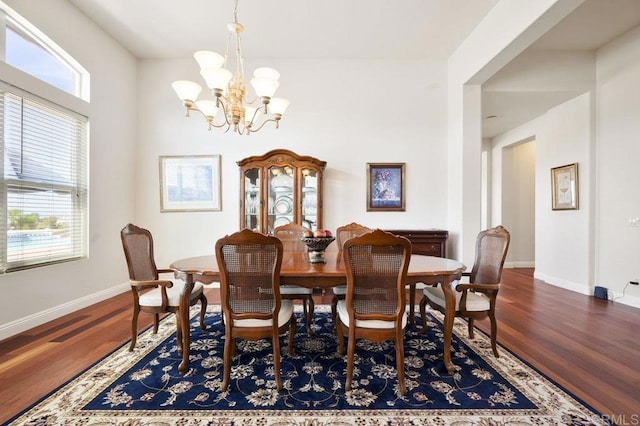 dining space featuring a notable chandelier, baseboards, and wood finished floors