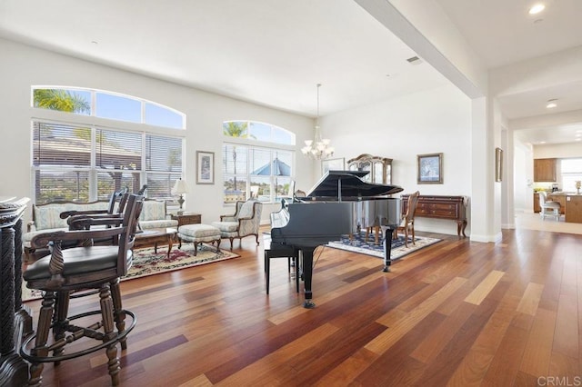 sitting room with a chandelier, a healthy amount of sunlight, baseboards, and wood finished floors