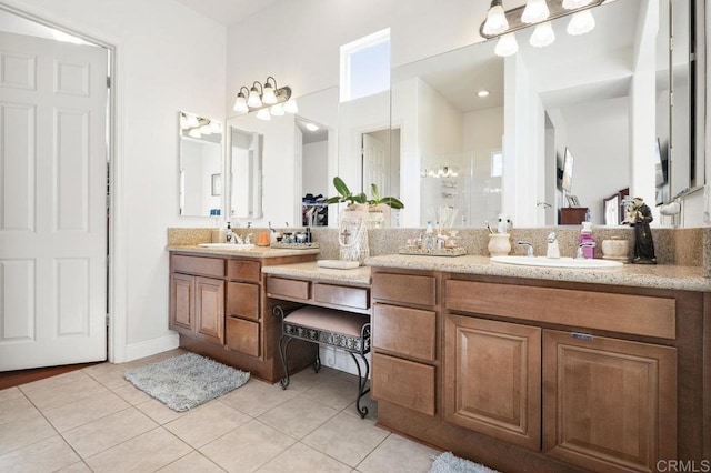 full bath featuring a shower stall, double vanity, a sink, and tile patterned floors