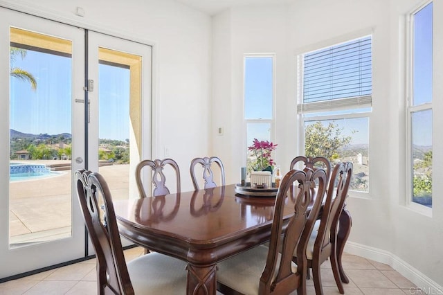 dining area featuring french doors, baseboards, and light tile patterned floors