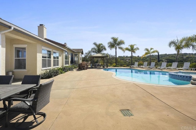 view of pool with a pool with connected hot tub, a patio, and a gazebo