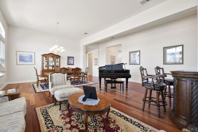 living room with a notable chandelier, baseboards, and wood finished floors