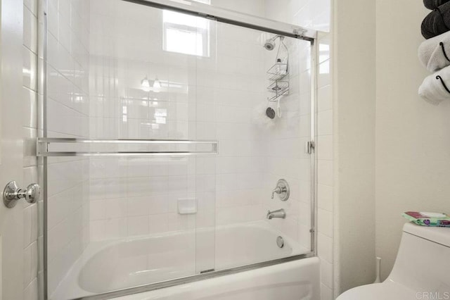 full bathroom featuring bath / shower combo with glass door and toilet