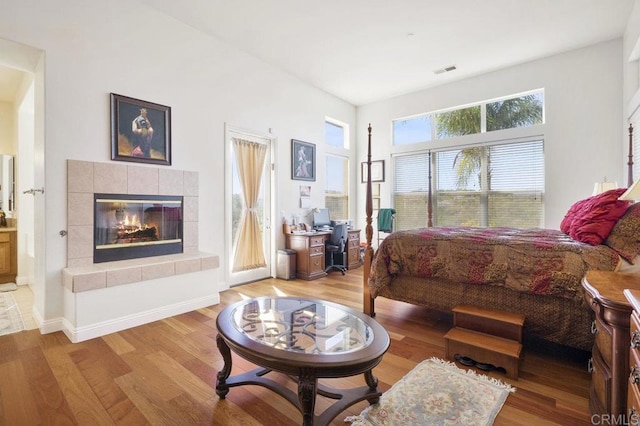 bedroom featuring a fireplace, visible vents, and light wood-style floors