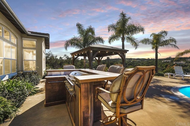 view of patio / terrace with outdoor dry bar and a gazebo