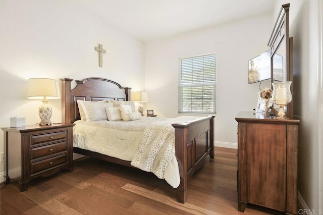 bedroom with dark wood-type flooring and baseboards