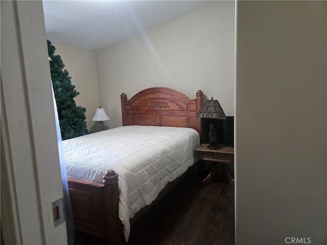 bedroom with dark wood-type flooring