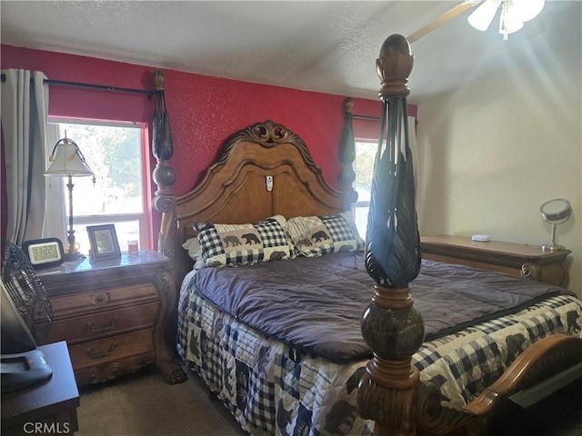 bedroom with a textured ceiling and dark carpet