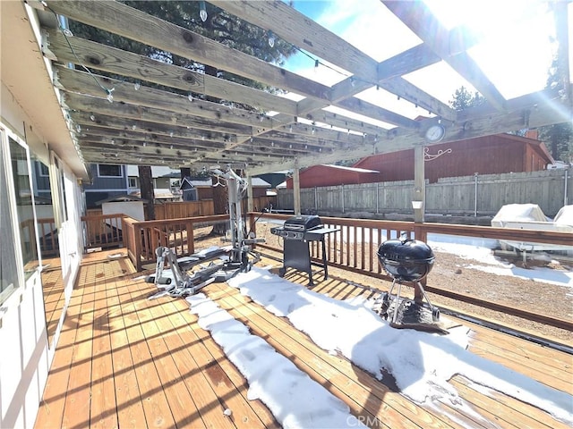 wooden terrace featuring a fenced backyard, grilling area, and a pergola