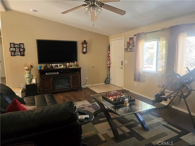 living room with lofted ceiling, baseboards, dark wood finished floors, and a ceiling fan