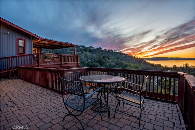 patio terrace at dusk with a deck and outdoor dining area