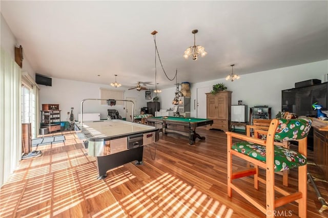 recreation room with pool table, wood finished floors, and a notable chandelier