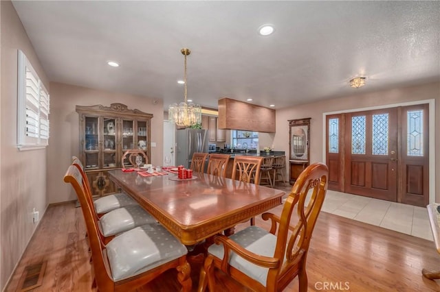 dining room featuring light wood-style flooring, an inviting chandelier, visible vents, and recessed lighting