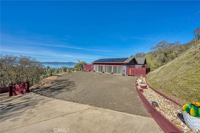 view of front of house with a water view and roof mounted solar panels