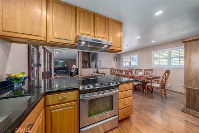 kitchen with under cabinet range hood, a sink, light wood-type flooring, stainless steel electric range, and dark stone counters