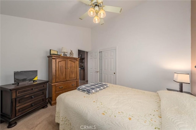 bedroom with light carpet, ceiling fan, a closet, and lofted ceiling