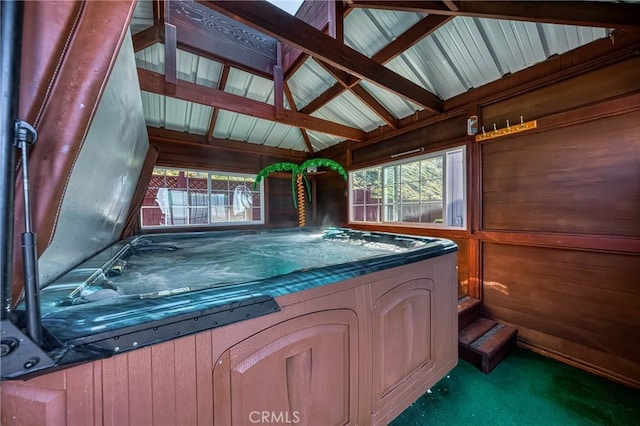 interior space with a hot tub and lofted ceiling with beams