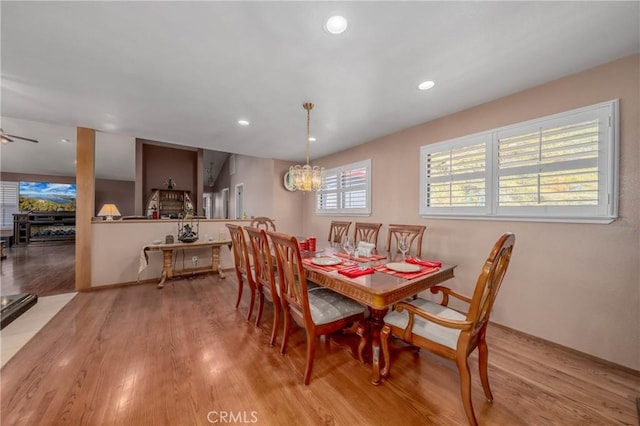 dining space with ceiling fan with notable chandelier, light wood-type flooring, and recessed lighting