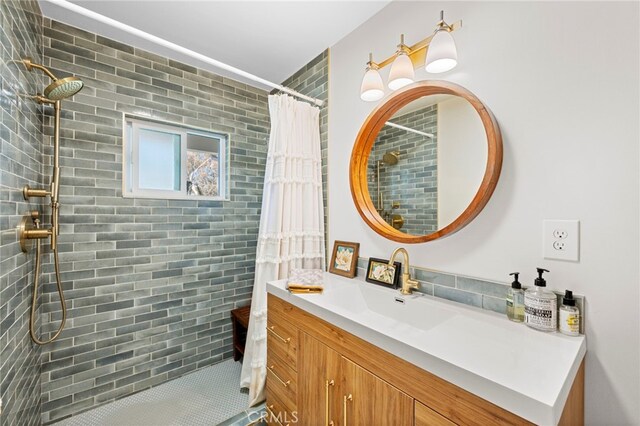 bathroom featuring a tile shower and vanity