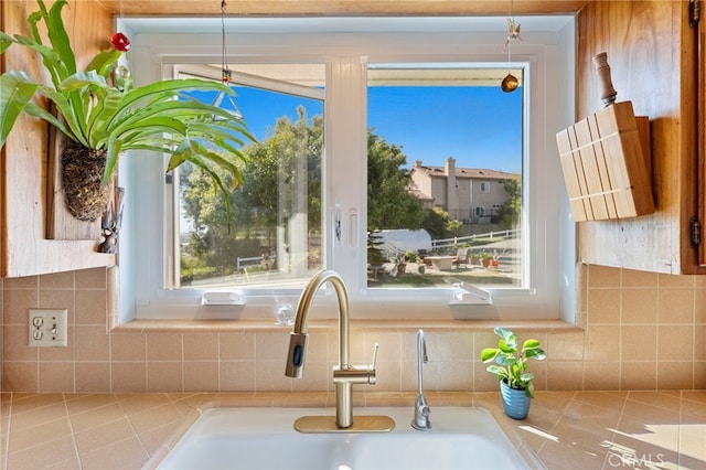 interior details with tasteful backsplash, light countertops, and a sink