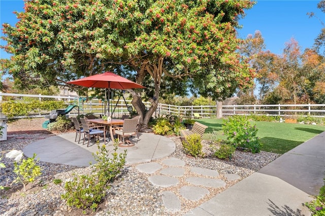 view of yard with a playground, fence, and a patio