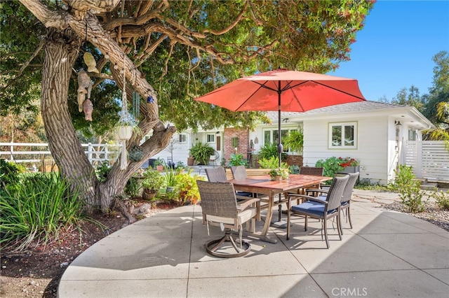 view of patio featuring outdoor dining area and fence