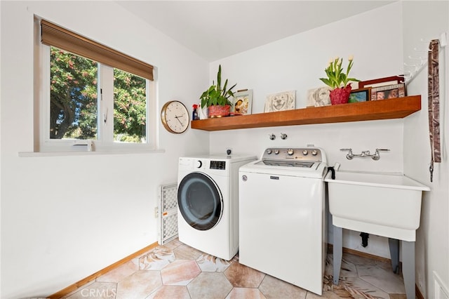 laundry room featuring laundry area, washing machine and clothes dryer, and baseboards