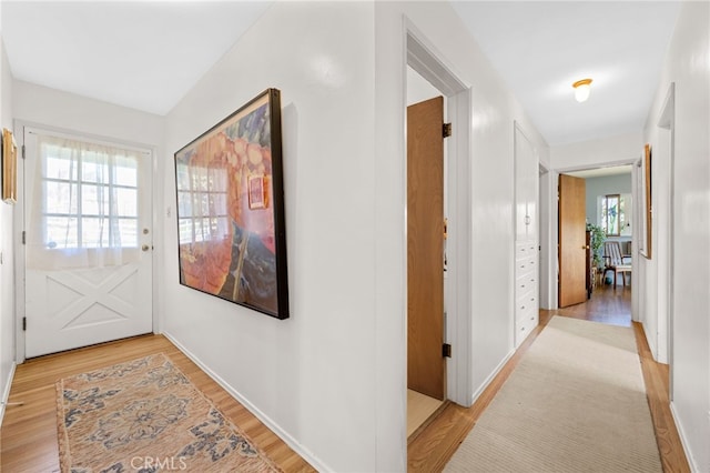 hall featuring baseboards and light wood-style floors