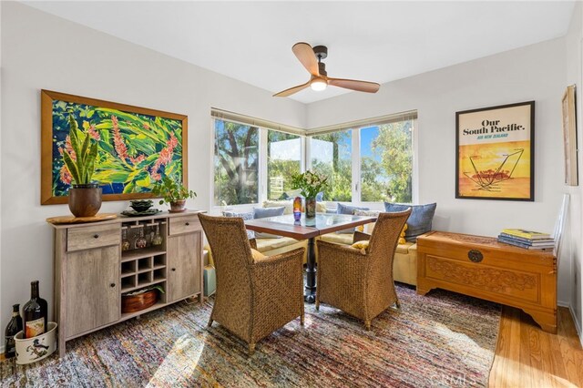 dining space with wood finished floors and a ceiling fan