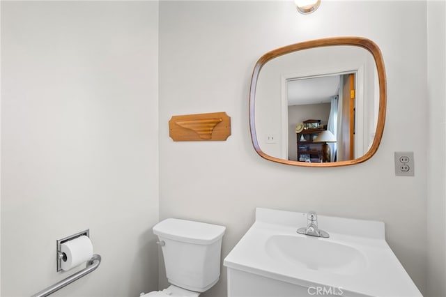 half bathroom with vanity and toilet