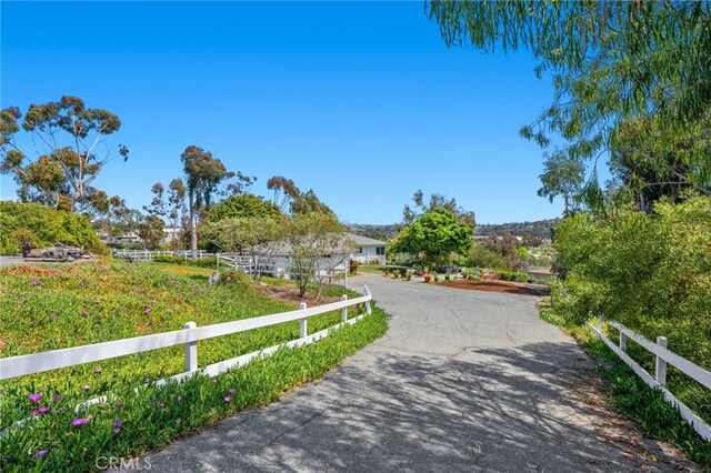 view of home's community featuring fence and aphalt driveway