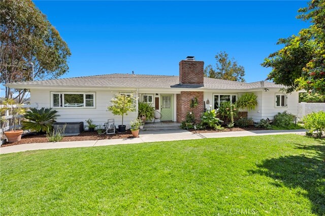 single story home featuring a chimney, fence, and a front yard