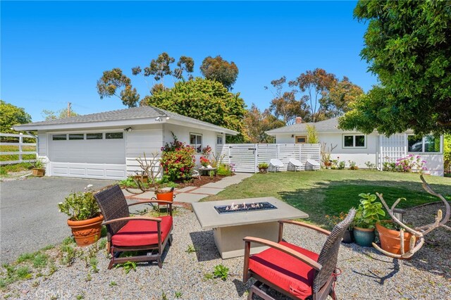 view of yard with fence, an outdoor fire pit, an outbuilding, and a garage