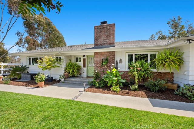 single story home with fence, a front lawn, a chimney, and brick siding