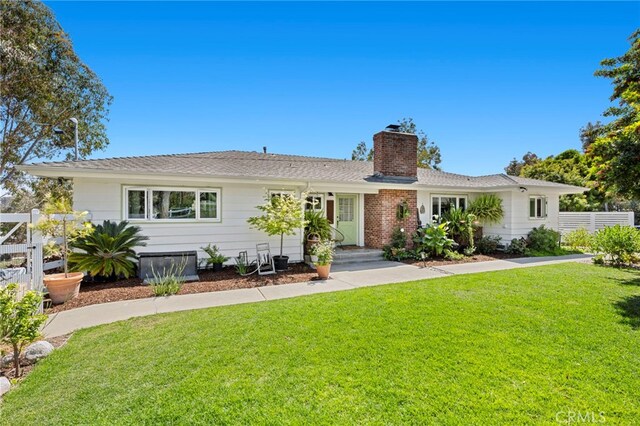 ranch-style home with fence, a front lawn, and a chimney