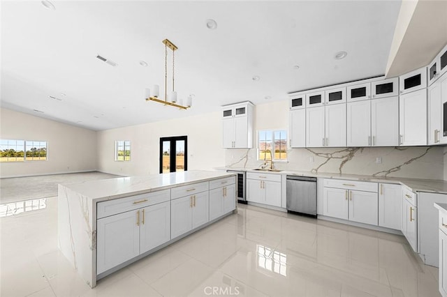 kitchen featuring a sink, open floor plan, hanging light fixtures, dishwasher, and glass insert cabinets