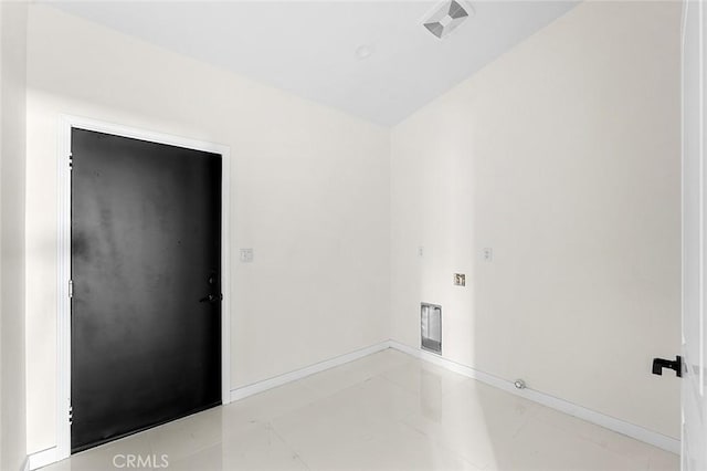 spare room featuring baseboards and light tile patterned floors