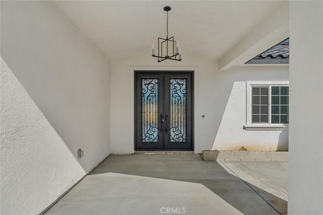 property entrance featuring french doors and stucco siding