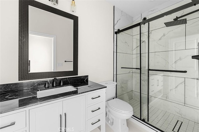 bathroom with toilet, vanity, and a shower stall