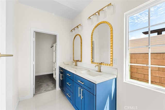 bathroom featuring double vanity, baseboards, and a sink